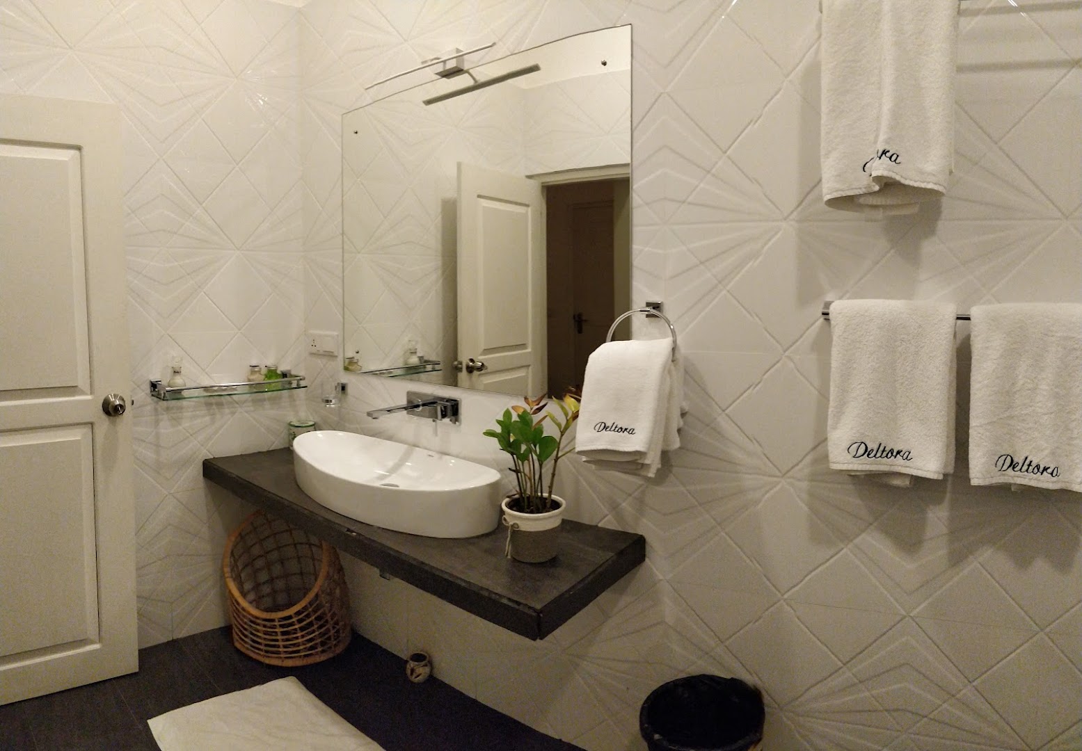 Deltora Villa en-suite bathroom with diamond-tile walls and branded Deltora towels