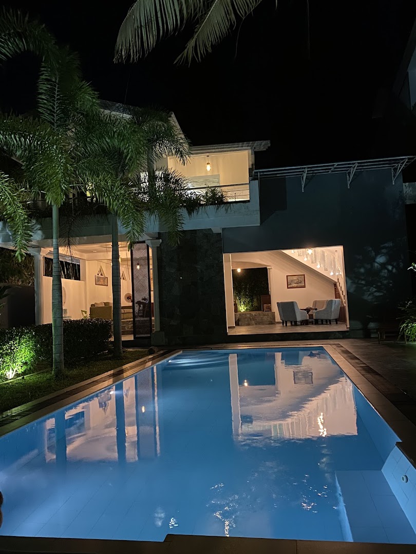 Deltora Villa at dusk, garden and pool illuminated by warm uplighting
