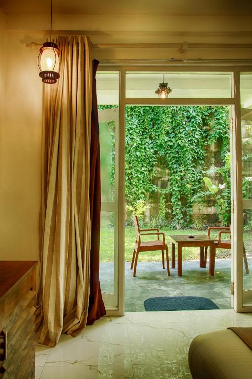 Deltora Villa Deluxe Family Room — room opening through sliding doors to the tropical garden