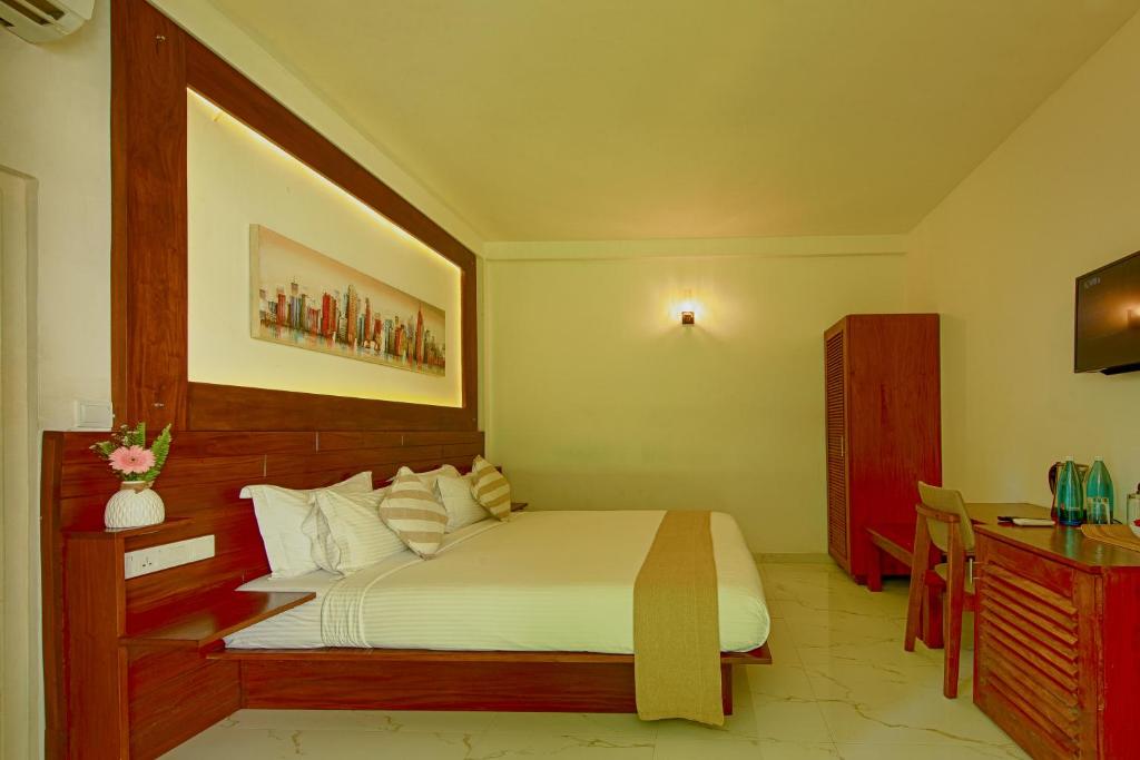 Deltora Villa Deluxe King Room — extra-large bed, warm wood headboard, air-conditioned